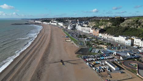 Aerial-drone-shot-of-Hastings-UK,-Wide-Tracking-shot-over-Hastings-Beach,-Hastings-Pier-and-coast-line