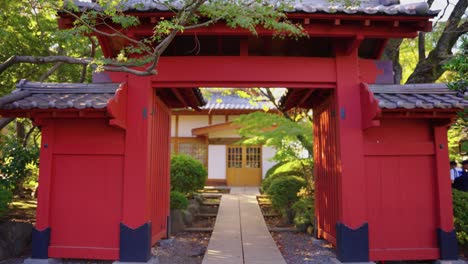 Slow-motion-tilt-down-over-red-gate-in-Japanese-shrine,-Gotokuji-Temple
