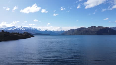 Drone-walkthrough-along-Lake-Wanaka-that-provides-a-captivating-and-immersive-experience,-showcasing-the-beauty-of-the-lake-and-its-surroundings-from-a-unique-aerial-perspective