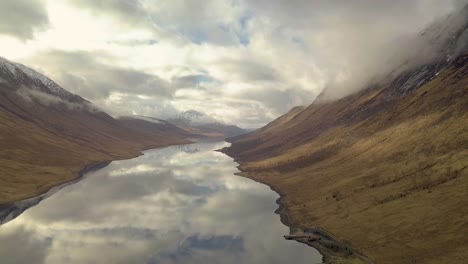 Cinematic-drone-shot-of-Scotland-highlands-with-Glen-Etive-Lake-during-cloudy-sky-and-reflection-on-water-surface---wide-shot