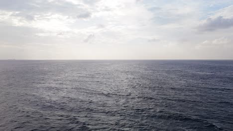 Panoramic-view-of-strong-current-waves-rocking-across-ocean-surface,-drone-descends