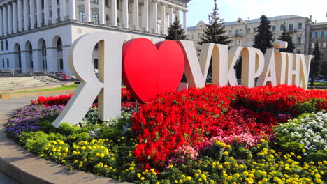 I-love-Ukraine-sign-on-Khreshchatyk-main-street-with-flowers-in-Kyiv-city-capital-Ukraine,-beautiful-city-center-with-plants-and-buildings,-4K-shot