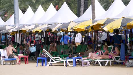 Turistas-Tumbados-En-Sillas-De-Playa-En-La-Playa-De-Pattaya,-En-La-Provincia-De-Chonburi,-En-Tailandia.