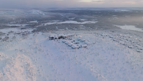 Aerial-view-overlooking-the-top-of-the-Iso-Syote-fell,-winter-sunrise-in-Finland