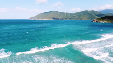 Gliding-over-turquoise-waters-and-golden-sands-in-Tayrona-National-Park,-Colombia