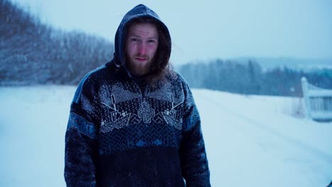 A-Man-in-a-Hooded-Sweatshirt-is-Standing-Beneath-the-Descending-Snow---Static-Shot