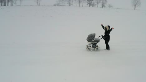 Mother-with-baby-carriage-wave-hands-for-help-during-severe-winter-snowfall