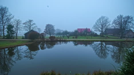 Night-to-day-timelapse-of-foggy-pond-with-homes-looking-out-over-water