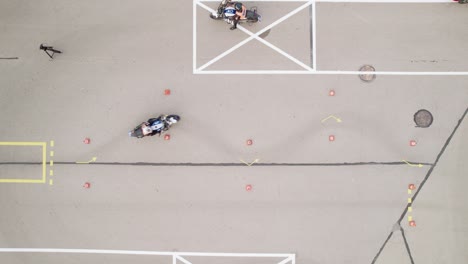 Aerial-Shot-of-Biker-Driving-Slalom-Through-Cones-on-the-Motorcycle