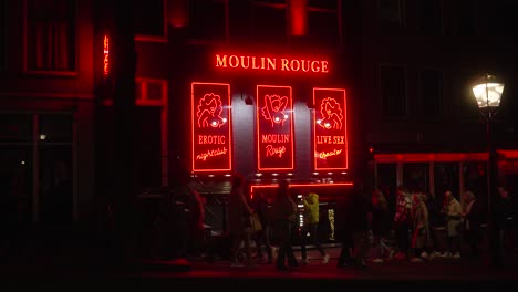 Menschen,-Die-Vor-Der-Leuchtreklame-Der-Erwachsenenbar-Moulin-Rouge-Im-Amsterdamer-Rotlichtviertel-Laufen