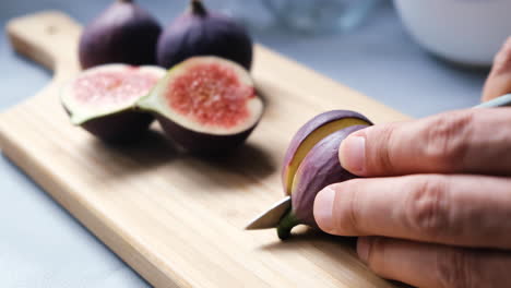 Hands-of-the-chef-cutting-figs-on-cutting-board