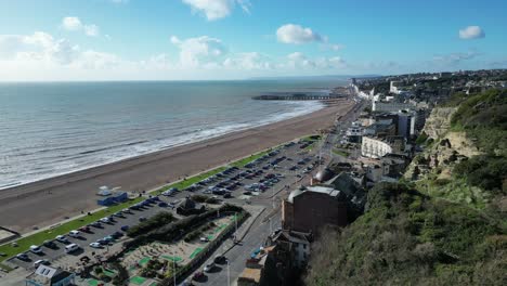 Aerial-drone-shot-of-Hastings-UK,-Wide-Tracking-shot-of-Hastings-Beach,-Hastings-Pier-and-coast-line