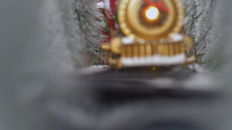 Close-up-of-a-toy-train-passing-through-a-snowy-landscape