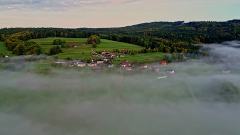 Thick-layer-of-misty-fog-clouds-spread-across-mountainous-village-homes-on-terraced-fields-in-the-forest