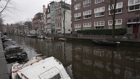 Docked-boats-in-residential-neighbourhood-in-Amsterdam,-city-center-canal