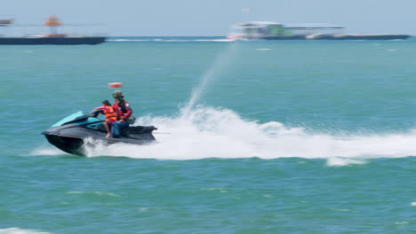 Touristen-Haben-Spaß-An-Verschiedenen-Wassersportarten,-Während-Sie-An-Einem-Strand-In-Pattaya,-In-Der-Provinz-Chonburi-In-Thailand,-Auf-Einem-Bananenboot,-Einem-Schnellboot-Und-Jetskis-Fahren
