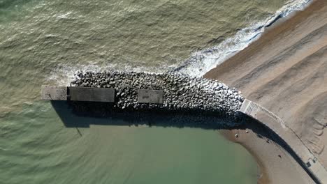 Drone-shot-of-Hastings-UK,-top-down-shot-flying-over-Land-Based-Fishing-Fleet-wave-breaker