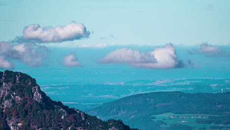 Über-Weitläufigen-Bewaldeten-Bergen-Türmen-Sich-Wolken,-Die-Am-Himmel-Wachsen-Und-Verblassen