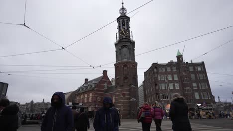 Pedestrians-walking-over-crosswalk-in-city-center-of-Amsterdam-with-the-Munttoren-in-the-background