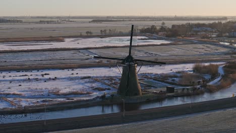 Historic-Dutch-windmill-in-winter-landscape-at-sunrise,-Haastrecht