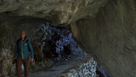 Wanderer-Geht-Durch-Den-Höhlentunnel-In-Valmalenco,-Totalaufnahme,-Handheld,-Tag