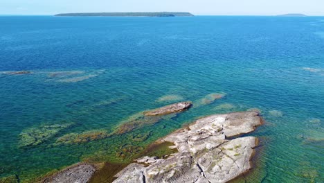 Aerial-Flying-Over-Granite-Rocks-Poking-Through-Turquoise-Waters-In-Georgian-Bay-Boarding-Ontario-Candaa