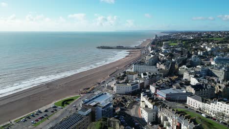 Aerial-drone-shot-of-Hastings-UK,-Wide-Pull-Away-Tracking-shot-over-top-of-Hastings-Castle,-Hastings-Beach,-Hastings-Pier-and-coast-line