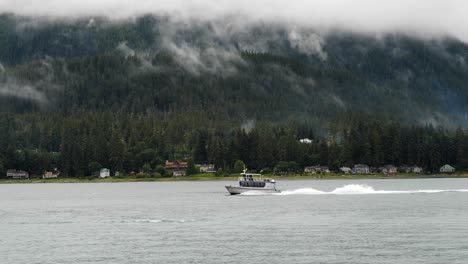 Montañas-Nubladas-Y-Un-Pequeño-Barco-Navegando-Por-El-Canal-Gastineau,-Juneau,-Alaska.