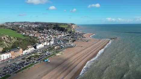 Aerial-drone-shot-of-Hastings-UK,-Wide-Tracking-shot-of-the-Land-Based-Fishing-Fleet-of-Beach,-Old-Town-and-East-Hill-Cliff-and-coast-line