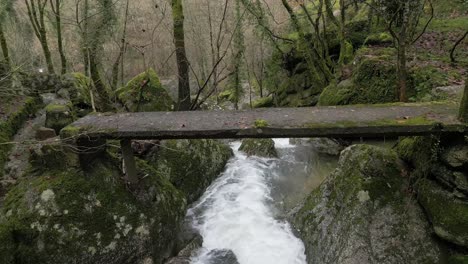 Rustic-Wooden-Bridge-Over-Forest-Stream---aerial