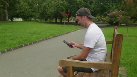 Relaxed-moments-on-a-bench,-scrolling-on-the-phone,-enjoying-leisure-time