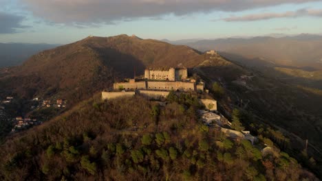 Forte-Sperone-on-a-hilltop-at-sunset,-overlooking-Genoa,-aerial-view