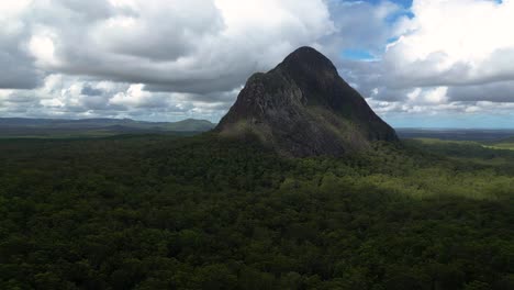 Right-to-left-aerial-view-of-the-North-face-of-Mt-Beerwah,-the-tallest-of-the-Glasshouse-Mountains-on-the-Sunshine-Coast,-Queensland,-Australia