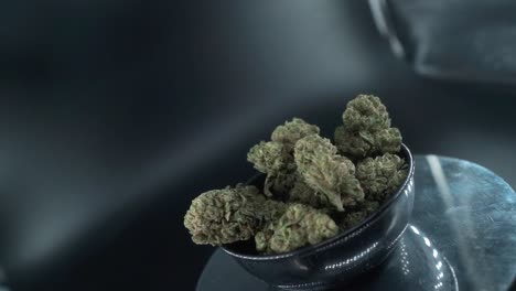 Green-Dried-Marijuana-Buds-Close-Up-Shot,-pile-of-dried-marijuana-plants-in-a-shiny-bowl,-trichomes-strains,-on-a-reflecting-rotating-stand,-studio-lights,-cinematic-smooth-rotate-slow-motion-120-fps