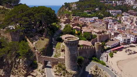 Flying-to-the-left-above-a-castle-on-the-edge-of-the-sea-in-Italy