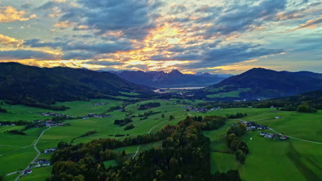 Episches-Sonnenuntergangslicht-Trifft-Auf-Wolken-Mit-Gelben-Streifen-über-Einem-Wunderschönen-Europäischen-Bauernhof-Und-Tal