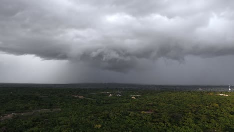 Aerial-approaching-shot-of-emerging-dramatic-storm-with-grey-sky-over-green-scenery-in-Dominican-Republic
