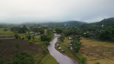 Mueang-Khong-early-in-the-Morning-covered-in-Fog,-Camping-by-the-River,-Foggy-Morning-in-Mountain-Village-River-South-East-Asian-Countryside