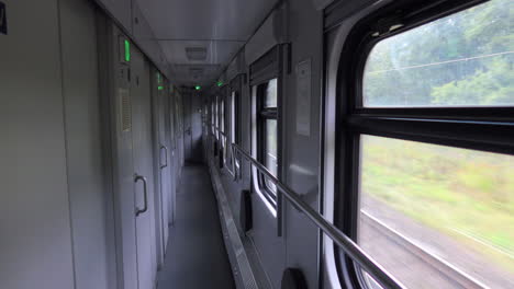 Empty-hallway-inside-a-fast-moving-Ukrainian-Railways-Ukrzaliznycia-train,-nature-outside,-4K-shot