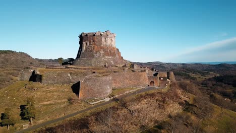 drone-shot-around-chateau-de-Murol-in-Auvergne-on-a-winter-sunny-day,-puy-de-dome-departement,-auvergne-rhone-alpes-region,-french-countryside