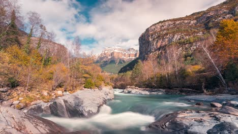 River-in-Ordesa-National-park-Mondarruego-mountain-timelapse-in-fall-autumn-season-an-a-beautiful-blue-sky-and-cloud-morning-pyrenees-mountains