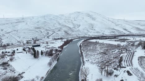 Drone-shot-of-the-Yakima-River-winding-through-Washington's-snow-covered-mountains