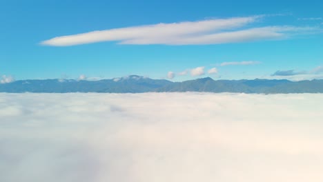 Carpet-of-Clouds,-Thick-Cloud-Layer-with-Mountain-Background,-White-Sea-of-Mist-with-Clear-Blue-Sky,-Cloud-covered-Mountain-Valley-with-Mountain-Range