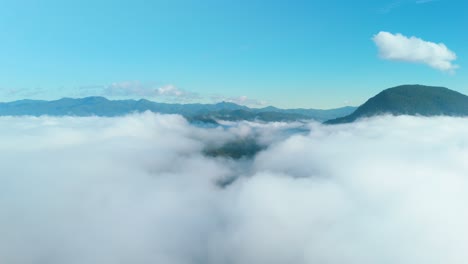 Above-the-Clouds-Impressive-Aerial-Timelapse,-Flying-over-the-Sea-of-Mist-with-Mountains-in-the-Background,-View-from-The-Airplane