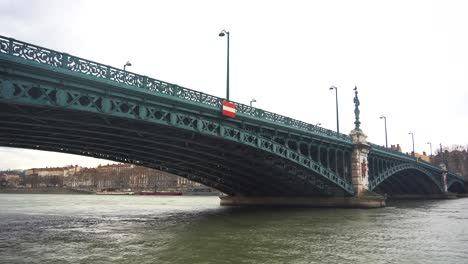 Stahlbrücke-Mit-Bögen-überspannt-Den-Ruhigen-Fluss-Rhône-In-Lyon-Und-Unterstreicht-Das-Wunderschöne-Stadtbild-Des-Historischen-Lyon,-Frankreich