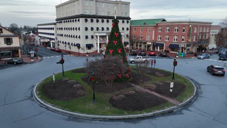 Decorated-Christmas-tree-in-center-of-roundabout-and-traffic-in-Gettysburg,-Pennsylvania---Aerial-orbiting-shot