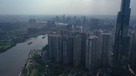 High-rise-buildings,-river-and-city-skyline-with-container-barges-on-the-river