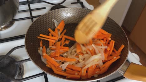 Carrots-and-julienned-onions-are-sautéed-in-a-pan