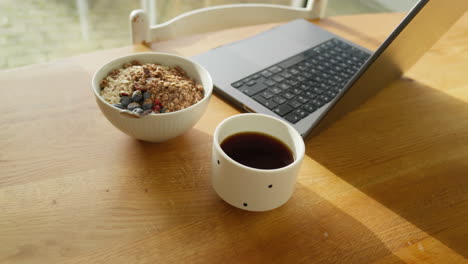 Remote-work-setup-with-laptop,-healthy-granola-bowl,-and-coffee
