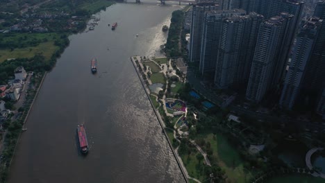 Wahrzeichen-Und-Umliegende-Hochhäuser,-Saigon-River-Mit-Containerbooten